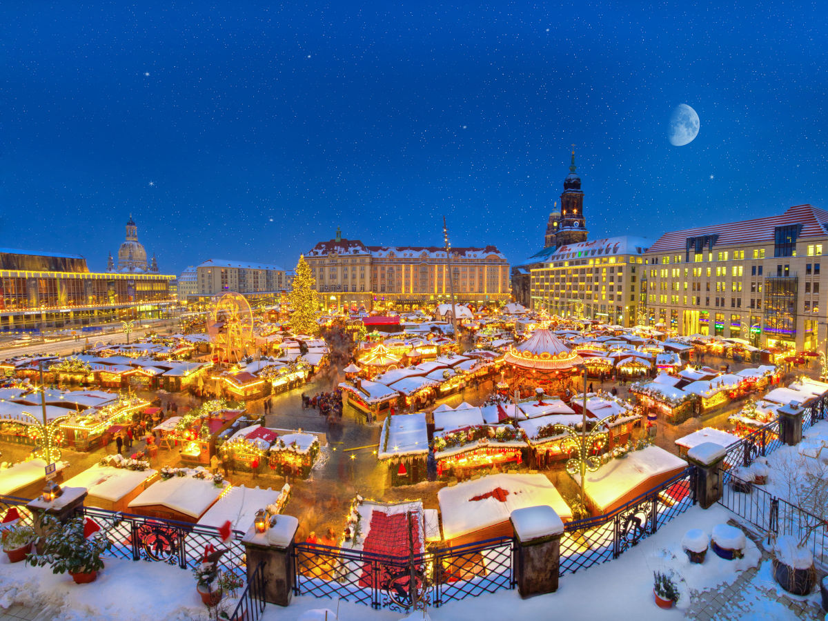 Der Dresdner Striezelmarkt präsentiert sich ganz in weiß in seinem winterlichen Gewand. Rechts im Hintergrund sind die Türme der Kreuzkirche und des Rathauses, links der Turm der Frauenkirche zu sehen. Foto: Torsten Hufsky (DML-BY) Dresden's Striezelmarkt presents itself all in white in its wintry garb. On the right in the background are the towers of the Kreuzkirche and the town hall, on the left the tower of the Frauenkirche. Photo: Torsten Hufsky (DML-BY)