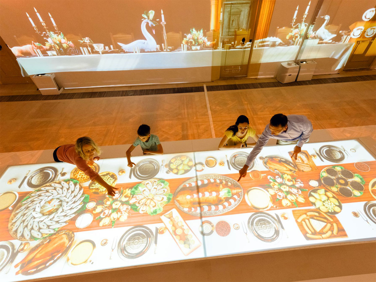 Familie probiert interaktive Festtafel in der Sonderausstellung "Kurfürst mit Weitblick" aus