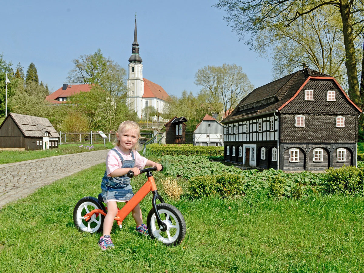 Kleines Mädchen im Umgebindehaus-Park in Cunewalde