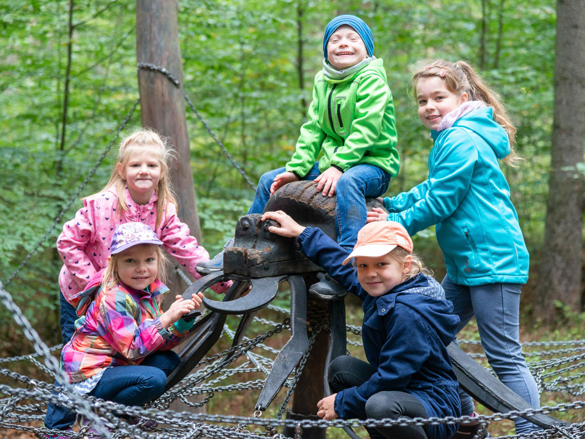 Kinder auf einem Spielplatz im Wald in der Waldhusche Hinterhermsdorf